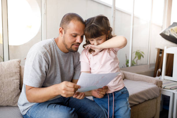 istock Little girl explaining her drawing to her father 1325949898