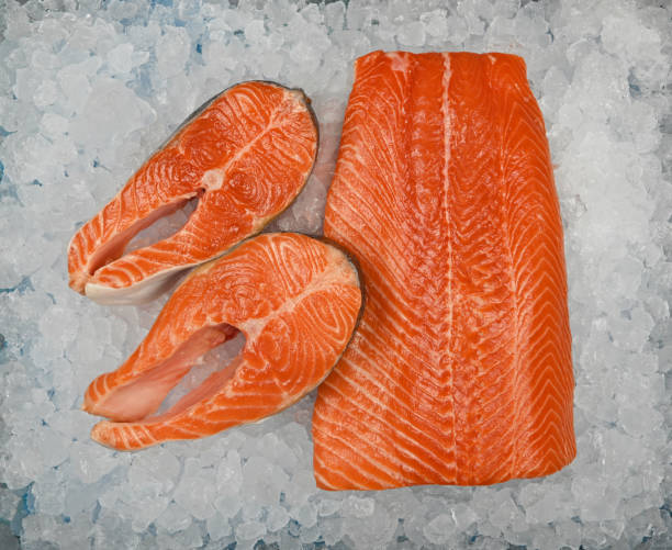 закройте крупным планом сырое филе лососевой рыбы и стейк на льду - freshness seafood crushed ice salmon стоковые фото и изображения