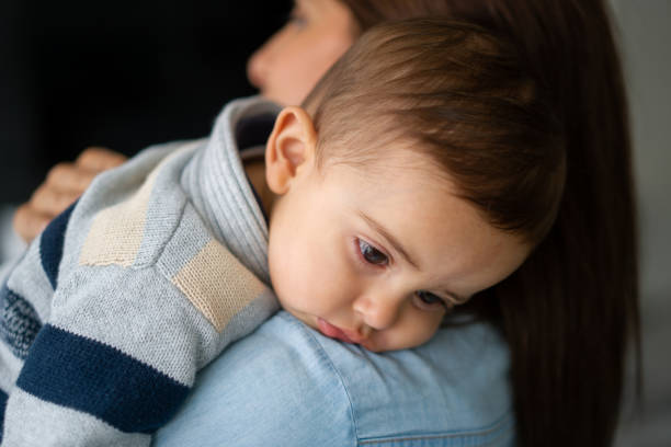 istock Close-up on a baby looking sad while her mother is carrying him 1325953679