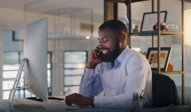 istock Shot of a young businessman talking on a cellphone while working on a computer in an office at night 1325954867