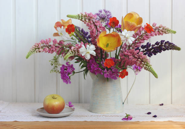 istock garden flowers and an apple on the table. 1325956097