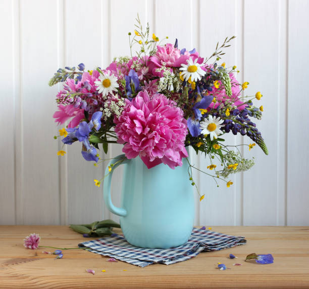 istock flowers in a blue jug on the table. 1325956387