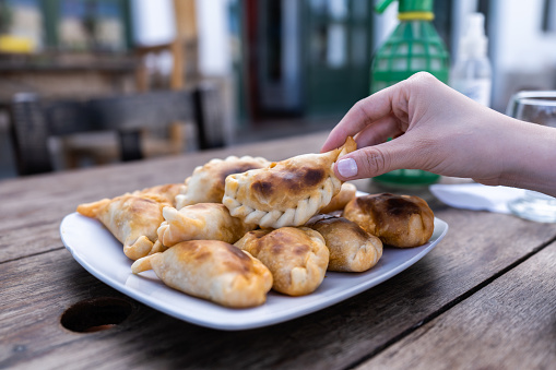 woman's hand holding an empanada - typical Argentine food