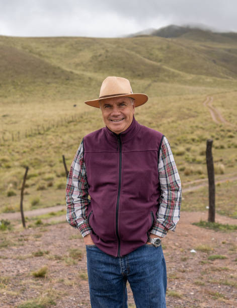 istock hispanic senior man with hat in a valley during a trip with mountains with clouds in the background - fresh air concept - latinx 1325957783