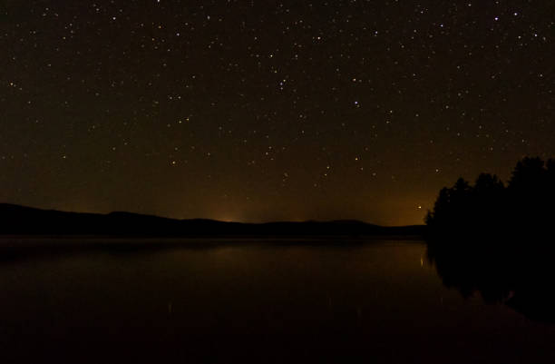 istock Beautiful starry night with a clear sky over a calm lake 1325957966