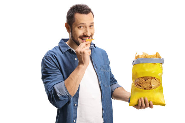 istock Handsome young man eating tortilla chips 1325959527