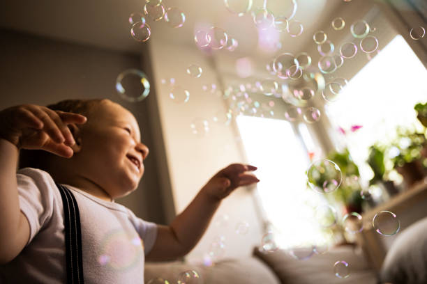 istock Baby Catching Soap Bubbles in living room 1325959543