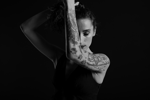 Black and white portrait of a tattoo artist on a black background.
