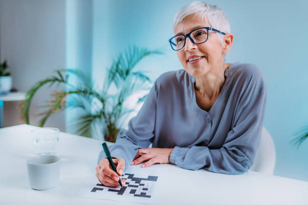 Crosswords. Cognitive Rehabilitation Therapy for Senior Woman. Crosswords. Cognitive rehabilitation therapy for senior women. neuropsychology stock pictures, royalty-free photos & images