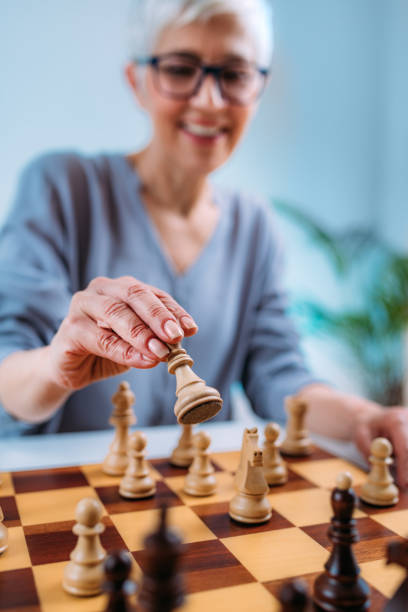 femme senior jouant aux échecs. thérapie de réadaptation cognitive. - brain case photos et images de collection