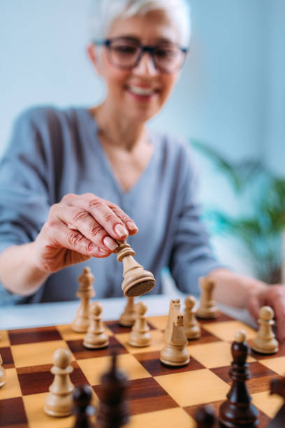 Senior Woman Playing Chess. Cognitive Rehabilitation Therapy. Senior woman playing chess. Cognitive rehabilitation therapy. neuropsychology stock pictures, royalty-free photos & images