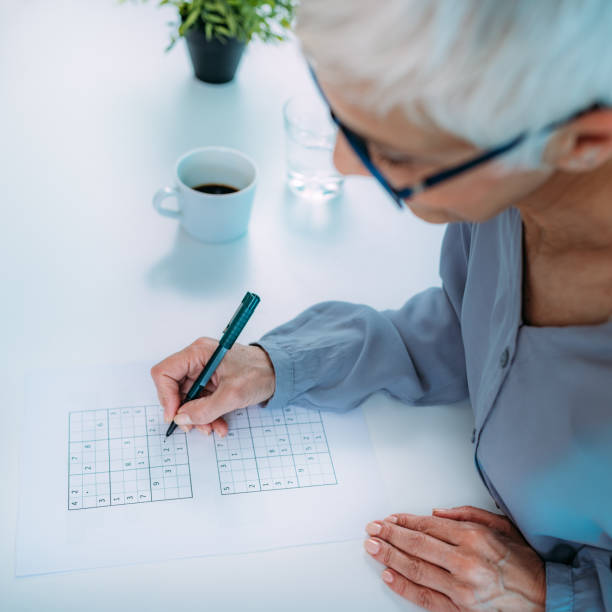 Cognitive Training. Senior Woman Solving Sudoku. Cognitive training. Senior woman solving sudoku puzzles. neuropsychology stock pictures, royalty-free photos & images