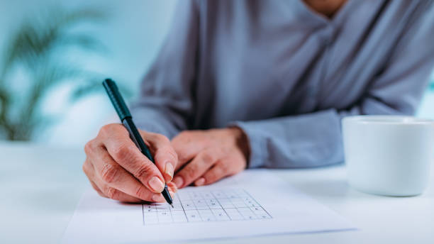 Senior Woman Solving Sudoku Puzzle. Cognitive Therapy for Senior Woman. Senior woman solving sudoku puzzle game. Cognitive enhancement therapy for seniors. neuropsychology stock pictures, royalty-free photos & images