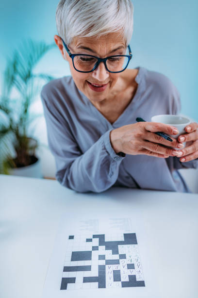 Crosswords. Cognitive Rehabilitation Therapy for Senior Woman. Crosswords. Cognitive rehabilitation therapy for senior women. neuropsychology stock pictures, royalty-free photos & images