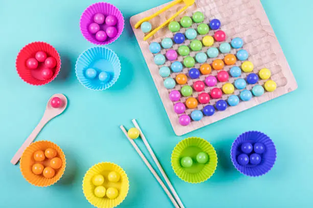 Photo of Wooden beads board game on blue background. New anti-stress and thinking logic toys for children and adult.