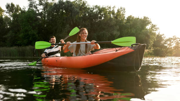 istock Joyful young couple having fun while kayaking in a river surrounded by the beautiful nature on a summer day 1325966185