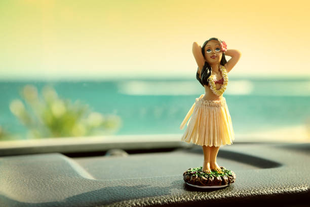 Hula dancer doll on Hawaii car road trip Hula dancer doll on Hawaii car road trip. Doll dancing on the dashboard in front of the ocean. Tourism and Hawaiian travel freedom concept. hula dancer stock pictures, royalty-free photos & images