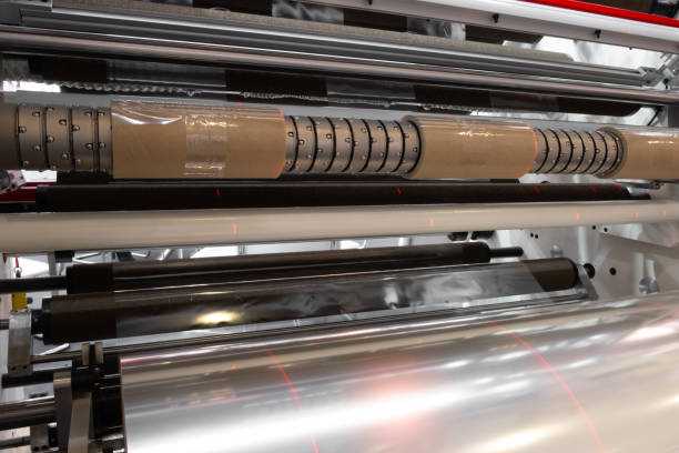 istock The operation of automatic plastic bag production machine with lighting effect. Close-up of the roller of the plastic bag production machine in the light blue scene with laser marking. 1325968980