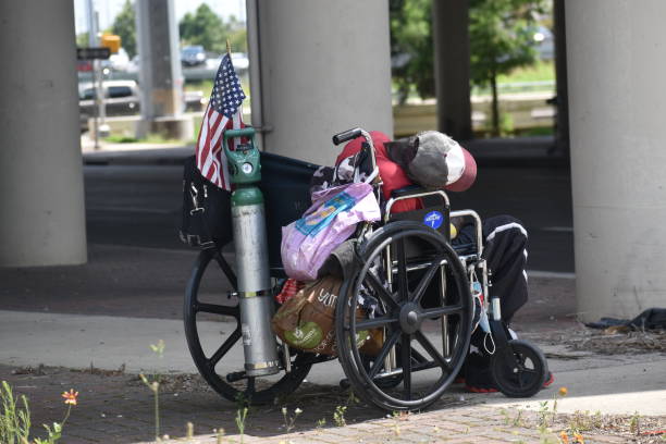 senzatetto e disabile che dormono sotto un'autostrada sopraelevata con la bandiera usa - depression sadness usa american flag foto e immagini stock