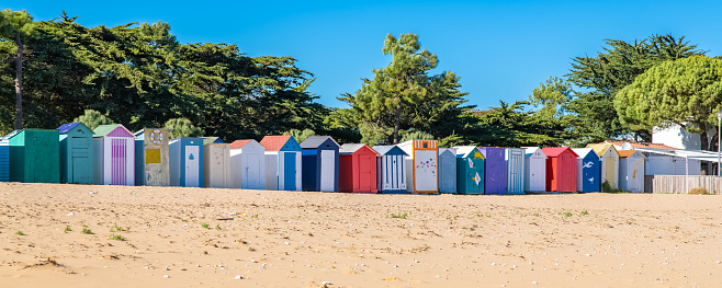 Valencia, Spain - August 2, 2020: Five wooden watercloset booths at the beach for public use. The city government install them as a free service to the people that visit the beach