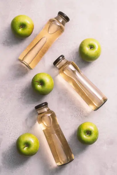 Apple juice and apples, directly above, table top shot. Fresh fruit juice in glass bottles.