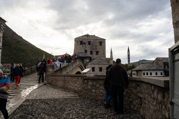 Tourists crossing the amazing Stari Most, Mostar. Tourists crossing the amazing Stari Most while enjoying the mesmerizing view. Bosnia and Herzegovina. stari most mostar stock pictures, royalty-free photos & images