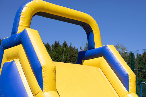 Children climb an inflatable slide. Inflatable obstacle course for fun. Active rest for children. Inflatable playground. Sports and fun.