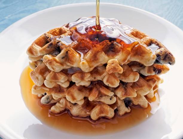 istock Stack of freshly prepared waffles with sweet maple syrup running down side of stack 1325976048