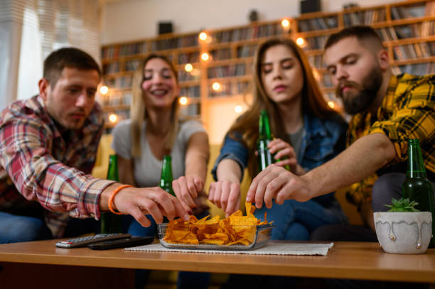 istock Friends eating nachos on a house party and having fun while drinking beer 1325979089