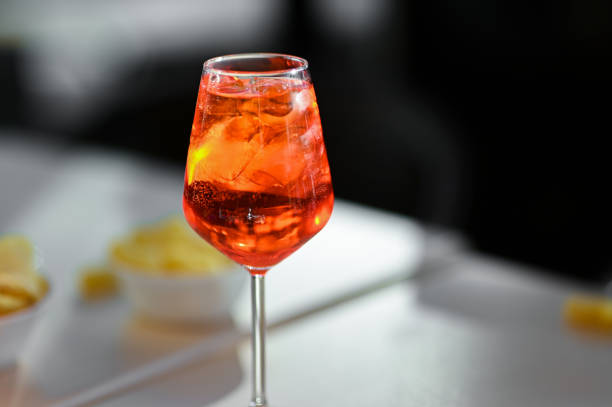 istock Italian cocktail Spritz in a wine glass with ice cubes. Selective focus with blurred background. Copy space text. Summer vacation concept 1325980748