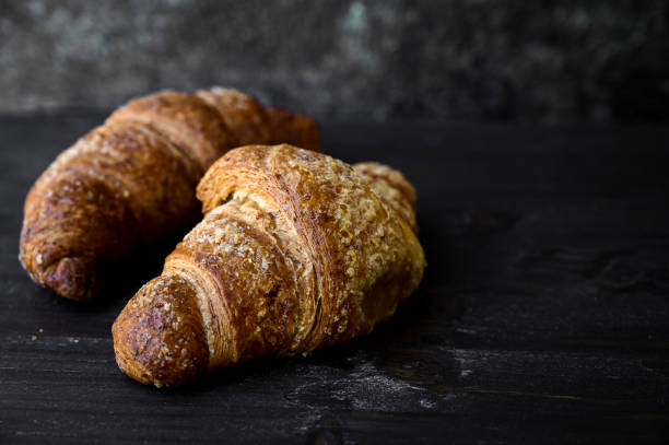 istock fresh crispy butter croissants laying on wood cutting board. 1325980749