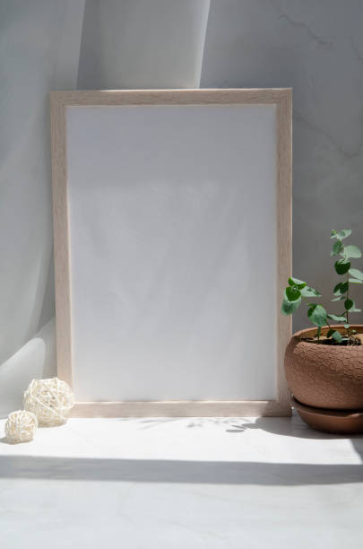 istock Blank sheet in a photo frame on the table. Mock up in a minimalist style. 1325980942