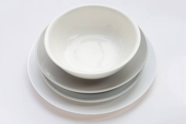 Stack of dishes and bowl on white background.