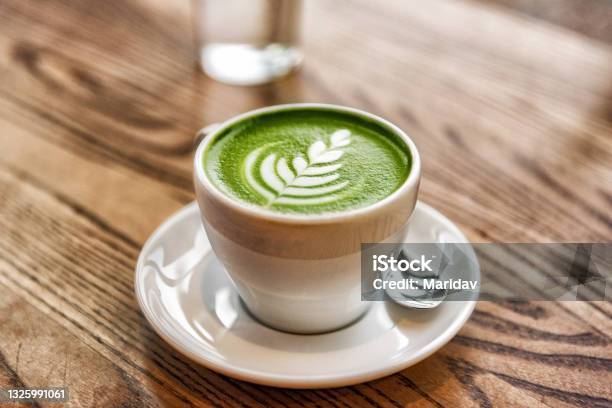 Matcha Latte Green Milk Foam Cup On Wood Table At Cafe Trendy Powered Tea Trend From Japan Stock Photo - Download Image Now