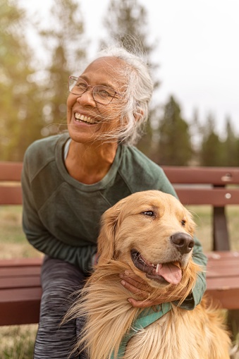 Mujer mayor étnica activa disfrutando del aire libre con su perro mascota photo