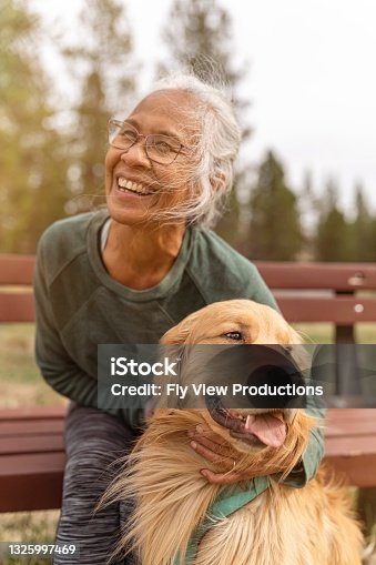 istock Active ethnic senior woman enjoying the outdoors with her pet dog 1325997469