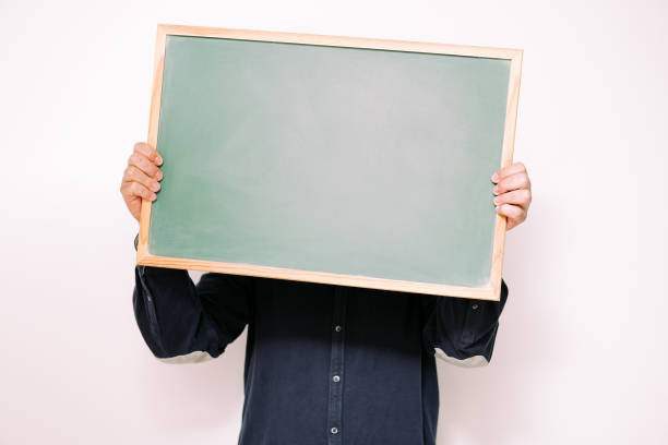 istock unrecognizable man covering face with blank sign 1325997648