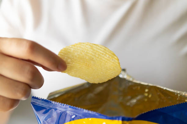 istock Hand hold potato chips with snack bag 1325998087