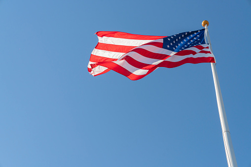 American flag waving with clear sky in background