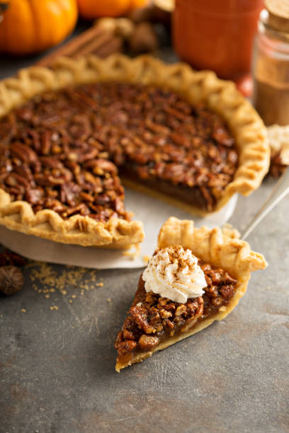 Pecan pie for Thanksgiving Pecan pie topped with whipped cream for Thanksgiving dessert pie stock pictures, royalty-free photos & images