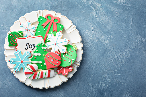 Christmas sugar and gingerbread cookies decorated with royal icing on a plate overhead