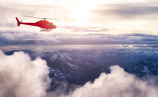 Red Color Helicopter flying over the Rocky Mountains during a sunny sunrise. Aerial Landscape from British Columbia, Canada near Vancouver. Epic Adventure Composite