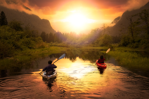 Adventure Friends Kayaking in Kayak surrounded by Canadian Mountain Landscape. Dramatic Sunset Art Render. Taken in Widgeon Valley, Pitt Meadows, Vancouver, British Columbia, Canada.