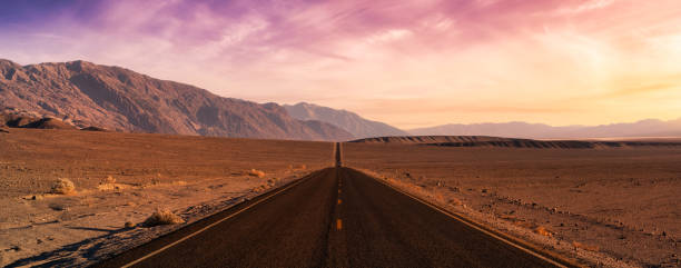 Panoramic view of a scenic road in the Death Valley National Park Panoramic view of a scenic road in the Death Valley National Park. Colorful Sunset Sky Art Render. Taken in California, United States of America. mojave desert stock pictures, royalty-free photos & images