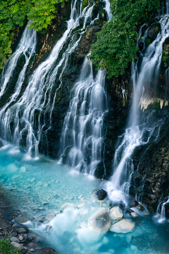 Shirahige waterfall biei river in summer. Beautiful nature blue water in countryside. Famous destination of tourist and traveller. Biei city Hokkaido japan.