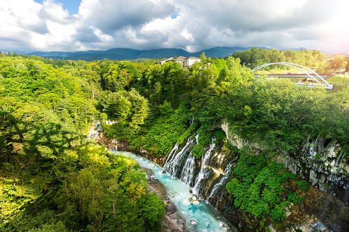 Shirahige waterfall biei river in summer. Beautiful nature blue water in countryside. Famous destination of tourist and traveller. Biei city Hokkaido japan.