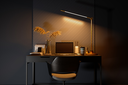Lugar de trabajo con computadora portátil, bloc de notas y lámpara brillante en el escritorio de estudio por la noche photo