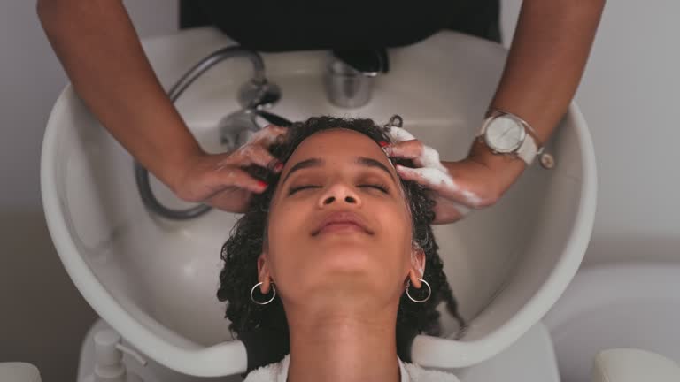 4k video footage of an attractive young woman getting her hair washed at a salon