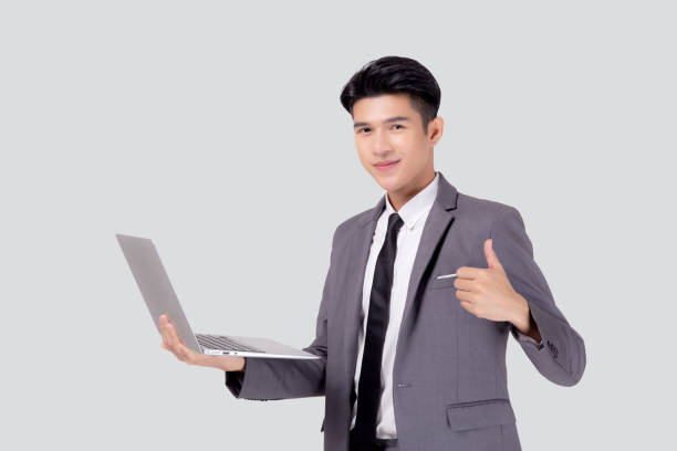 istock Young asian business man standing work on laptop computer to internet online isolated on white background, businessman confident and notebook, freelance with success, marketing and communication. 1326013165