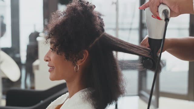 4k video footage of an attractive young woman getting her hair blow dried in a salon during the day